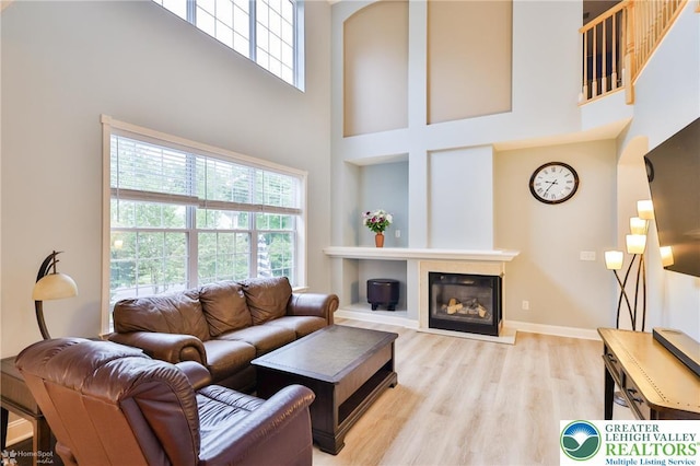 780 Ramblewood Dr, Forks Twp, PA 18040 - living area with a towering ceiling, plenty of natural light, wood finished floors, a glass covered fireplace, and arched walkways
