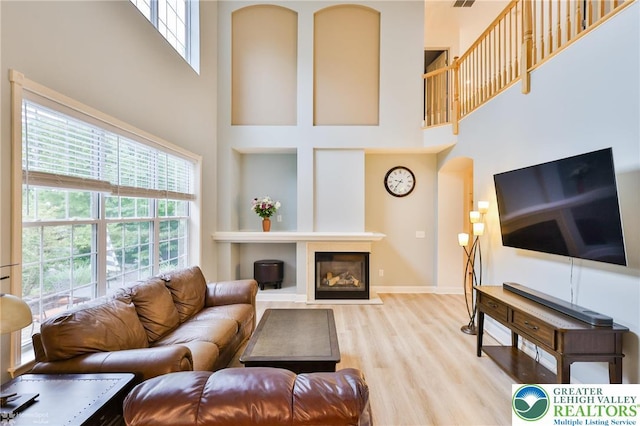 780 Ramblewood Dr, Forks Twp, PA 18040 - living area featuring a high ceiling, wood finished floors, a glass covered fireplace, and arched walkways
