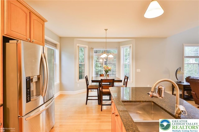780 Ramblewood Dr, Forks Twp, PA 18040 - kitchen with stainless steel refrigerator with ice dispenser, light wood-type flooring, dark stone countertops, light brown cabinets, and pendant lighting