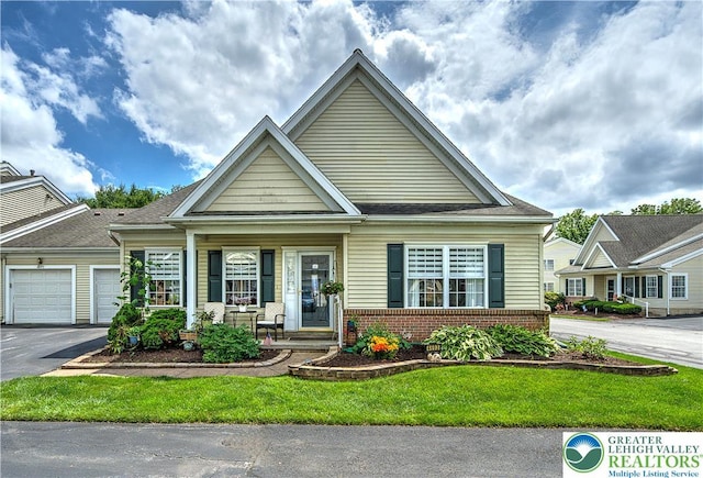 4693 Bluegrass Ln, Lower Macungie Twp, PA 18062 - view of front of house with brick siding, covered porch, a garage, asphalt driveway, and a front yard