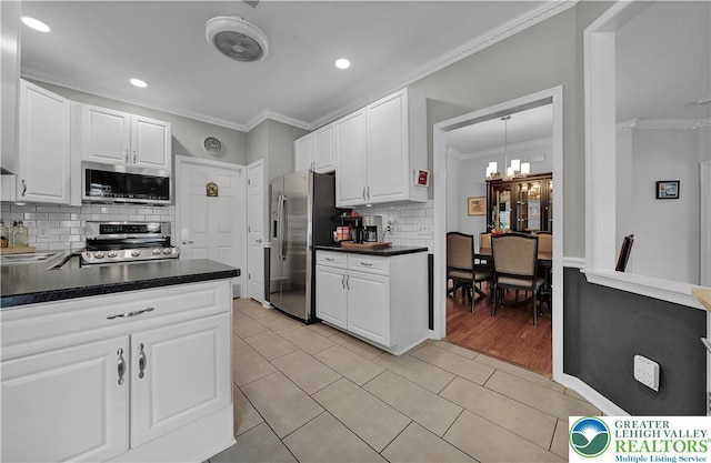 4693 Bluegrass Ln, Lower Macungie Twp, PA 18062 - kitchen with appliances with stainless steel finishes, dark countertops, light tile patterned floors, decorative backsplash, and white cabinetry
