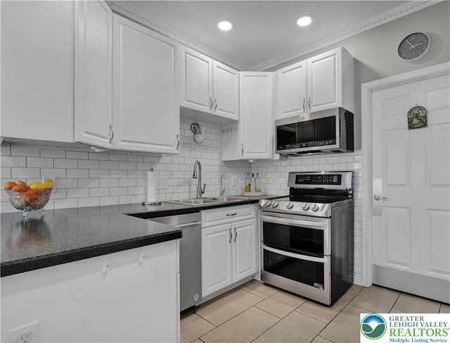 4693 Bluegrass Ln, Lower Macungie Twp, PA 18062 - kitchen with stainless steel appliances, white cabinetry, light tile patterned flooring, recessed lighting, and crown molding