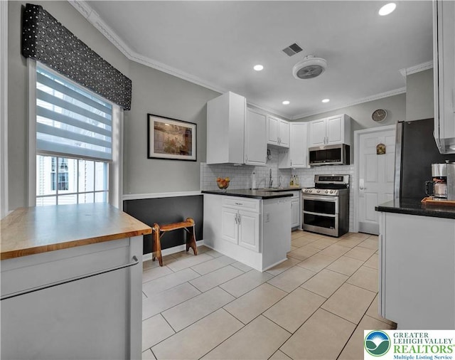 4693 Bluegrass Ln, Lower Macungie Twp, PA 18062 - kitchen with appliances with stainless steel finishes, crown molding, decorative backsplash, white cabinets, and light tile patterned floors