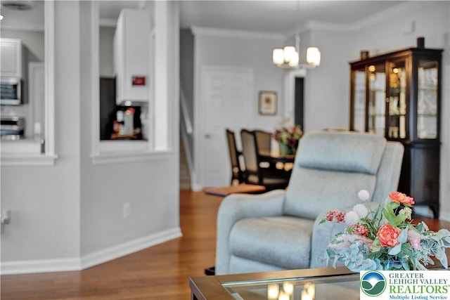 4693 Bluegrass Ln, Lower Macungie Twp, PA 18062 - living room featuring wood finished floors, a chandelier, and ornamental molding