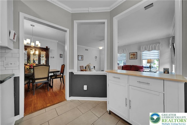 4693 Bluegrass Ln, Lower Macungie Twp, PA 18062 - kitchen featuring white cabinets, ornamental molding, light tile patterned floors, and a chandelier