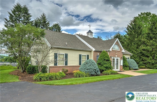 4693 Bluegrass Ln, Lower Macungie Twp, PA 18062 - view of front of home with brick siding, a shingled roof, french doors, and a chimney