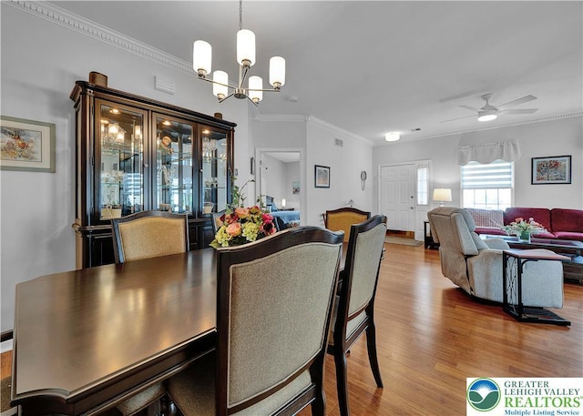 4693 Bluegrass Ln, Lower Macungie Twp, PA 18062 - dining space featuring wood finished floors, a chandelier, ornamental molding, and ceiling fan