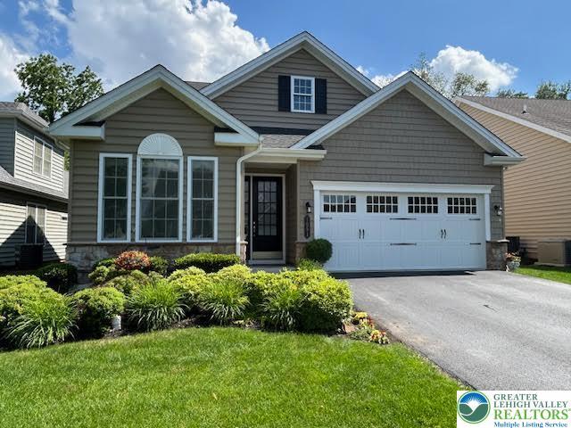 1051 Resolution Dr, Hanover Twp, PA 18017 - view of front of house with stone siding, asphalt driveway, a garage, and a front yard