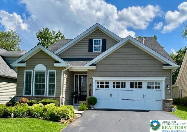 1051 Resolution Dr, Hanover Twp, PA 18017 - view of front facade featuring asphalt driveway, a garage, stone siding, and a shingled roof