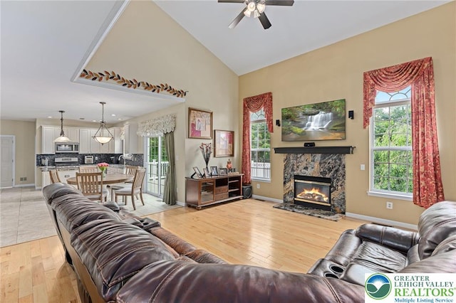 6841 Stone Croft Cir, Macungie Boro, PA 18062 - living area with light wood finished floors, a ceiling fan, a premium fireplace, and high vaulted ceiling