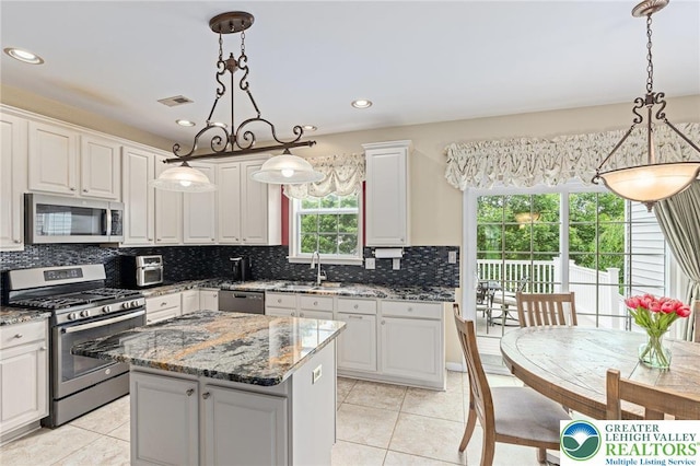 6841 Stone Croft Cir, Macungie Boro, PA 18062 - kitchen with appliances with stainless steel finishes, light tile patterned flooring, tasteful backsplash, a kitchen island, and recessed lighting