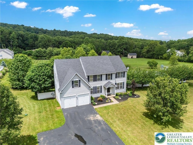 6841 Stone Croft Cir, Macungie Boro, PA 18062 - view of front of house with driveway, a front lawn, a wooded view, and a shingled roof