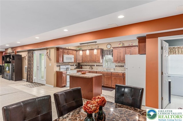 6841 Stone Croft Cir, Macungie Boro, PA 18062 - kitchen featuring white appliances, brown cabinetry, a center island, light countertops, and hanging light fixtures
