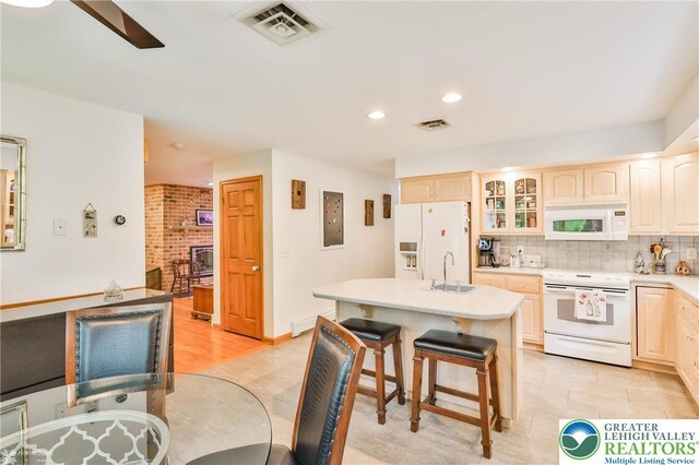 3745 Orefield Rd, South Whitehall Twp, PA 18104 - kitchen featuring white appliances, a kitchen breakfast bar, glass insert cabinets, tasteful backsplash, and a center island with sink