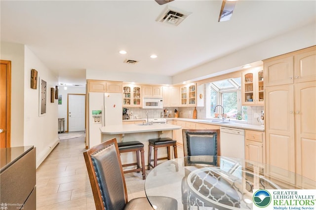 3745 Orefield Rd, South Whitehall Twp, PA 18104 - kitchen with white appliances, tasteful backsplash, glass insert cabinets, a kitchen island with sink, and light countertops