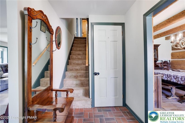 909 Interchange Rd, Polk Twp, PA 18333 - staircase featuring brick patterned flooring and a chandelier