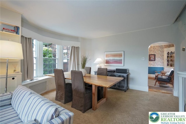 11 11 Ave, D, PA 17972 - dining room featuring arched walkways, light carpet, radiator heating unit, and wallpapered walls