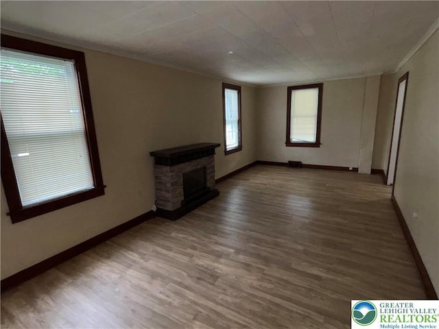 565 Moorestown Dr, Moore Twp, PA 18014 - unfurnished living room featuring wood finished floors, ornamental molding, and a stone fireplace