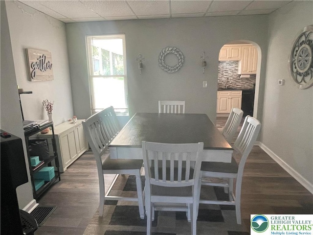 924 W Berwick St, Easton, PA 18042 - dining area featuring a paneled ceiling, arched walkways, and dark wood-style flooring
