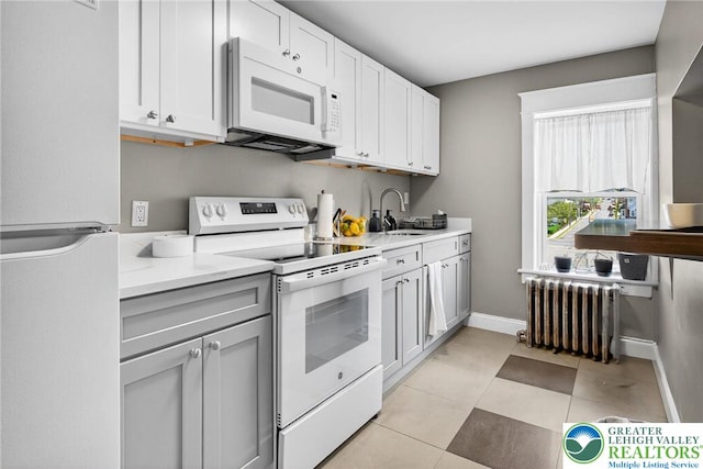 624 N Maxwell St, Allentown City, PA 18109 - kitchen with white appliances, radiator, light countertops, and light tile patterned floors