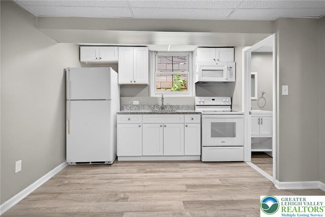 624 N Maxwell St, Allentown City, PA 18109 - kitchen with white appliances, white cabinetry, light wood-style flooring, a paneled ceiling, and light stone countertops