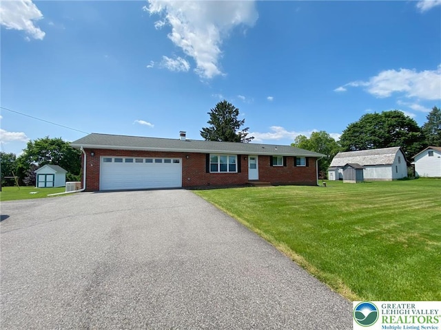 3111 Pheasant Dr, Moore Twp, PA 18067 - single story home featuring a storage unit, a front lawn, brick siding, asphalt driveway, and an attached garage