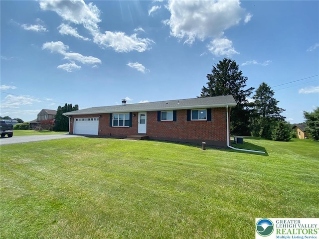 3111 Pheasant Dr, Moore Twp, PA 18067 - ranch-style home with driveway, brick siding, a garage, and a front lawn