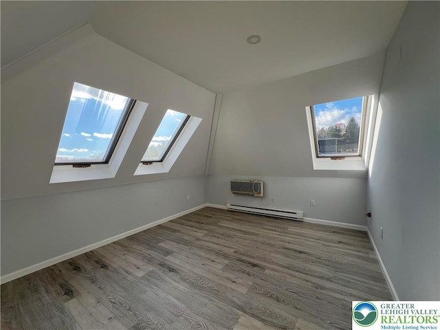 106 Lynx Ln, Chestnuthill Twp, PA 18330 - additional living space featuring a skylight, a baseboard radiator, an AC wall unit, wood finished floors, and lofted ceiling