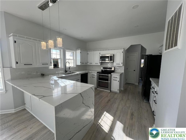 106 Lynx Ln, Chestnuthill Twp, PA 18330 - kitchen with black appliances, a peninsula, light wood-type flooring, and white cabinets