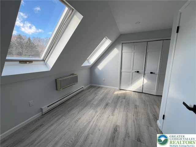 106 Lynx Ln, Chestnuthill Twp, PA 18330 - additional living space with baseboard heating, a skylight, wood finished floors, a wall unit AC, and lofted ceiling