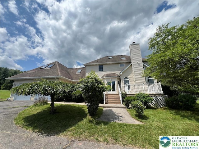 106 Lynx Ln, Chestnuthill Twp, PA 18330 - view of front of house with a front lawn, a wooden deck, a chimney, an attached garage, and driveway