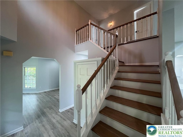106 Lynx Ln, Chestnuthill Twp, PA 18330 - staircase featuring wood finished floors, a high ceiling, and arched walkways
