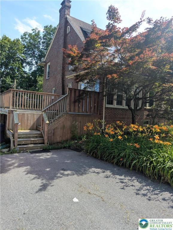 2816 W Columbia St, South Whitehall Twp, PA 18104 - view of property exterior with brick siding, stairway, a chimney, and a wooden deck