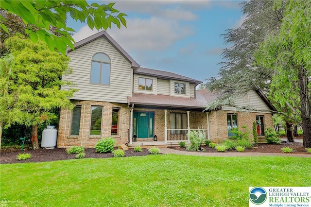 6242 Domarray St, Upper Saucon Twp, PA 18036 - view of front of home featuring covered porch, a front lawn, brick siding, and roof with shingles