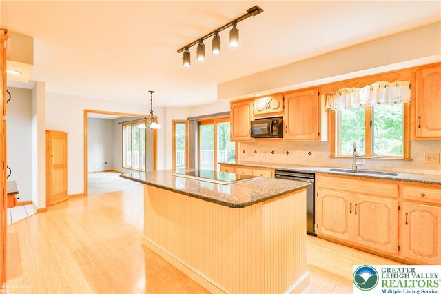 6242 Domarray St, Upper Saucon Twp, PA 18036 - kitchen featuring black appliances, backsplash, a center island, light stone countertops, and plenty of natural light