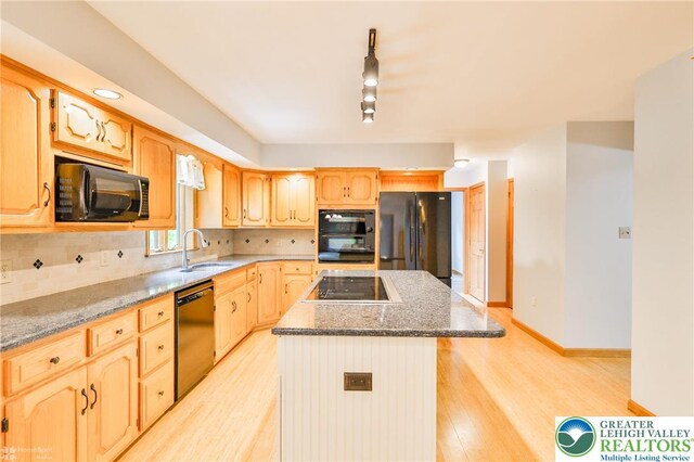6242 Domarray St, Upper Saucon Twp, PA 18036 - kitchen featuring black appliances, a center island, light brown cabinetry, light wood-style floors, and dark stone countertops