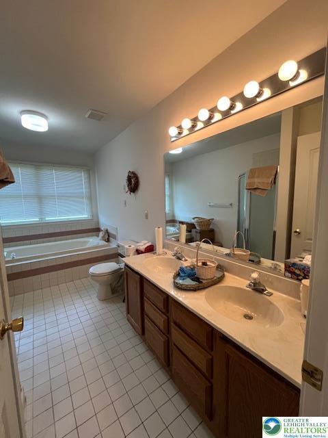 255 Ridings Cir, Macungie Boro, PA 18062 - bathroom with tile patterned flooring, double vanity, tiled tub, and an enclosed shower