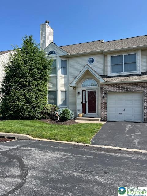 255 Ridings Cir, Macungie Boro, PA 18062 - view of front of home with asphalt driveway, a garage, brick siding, and a chimney