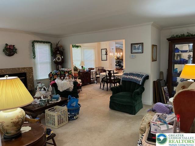 255 Ridings Cir, Macungie Boro, PA 18062 - carpeted living room featuring ornamental molding, a chandelier, and a fireplace