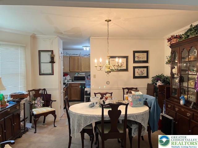 255 Ridings Cir, Macungie Boro, PA 18062 - dining space featuring a chandelier, light colored carpet, and crown molding