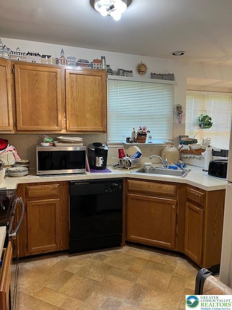 255 Ridings Cir, Macungie Boro, PA 18062 - kitchen featuring black dishwasher, stainless steel microwave, light countertops, and brown cabinetry
