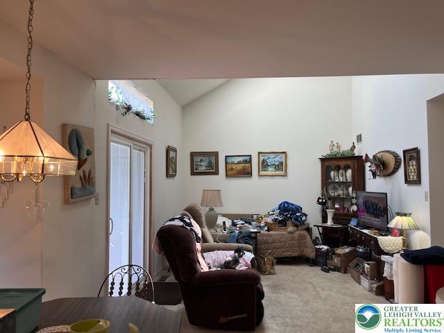 255 Ridings Cir, Macungie Boro, PA 18062 - living area with lofted ceiling, carpet floors, and a chandelier