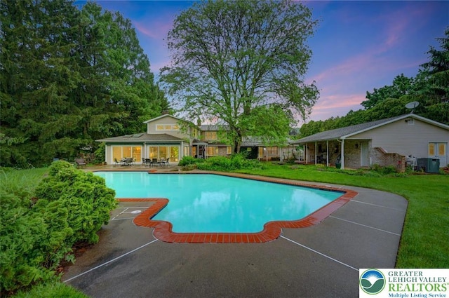 938 Meadow Cir, Bethlehem City, PA 18017 - pool at dusk featuring an outdoor pool, a patio area, and a yard