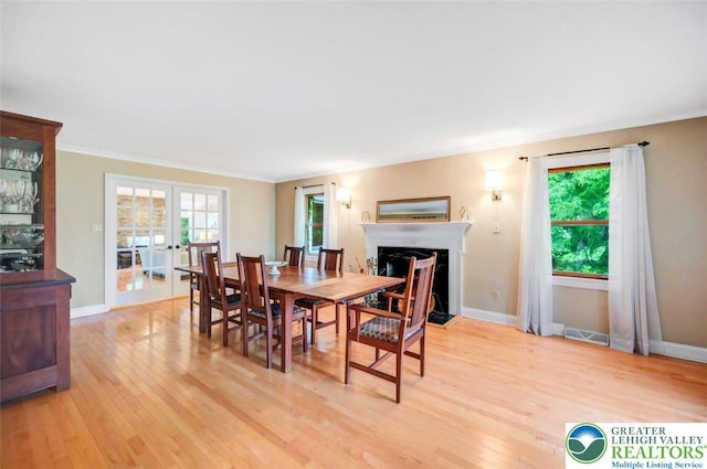 938 Meadow Cir, Bethlehem City, PA 18017 - dining room with light wood-style flooring, a fireplace with flush hearth, and ornamental molding
