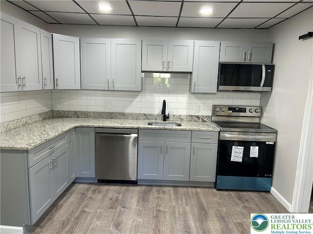 230 White St, Lehighton Boro, PA 18235 - kitchen with appliances with stainless steel finishes, light wood-type flooring, tasteful backsplash, gray cabinetry, and a paneled ceiling