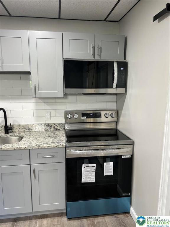 230 White St, Lehighton Boro, PA 18235 - kitchen featuring stainless steel appliances, gray cabinetry, light stone counters, and wood finished floors