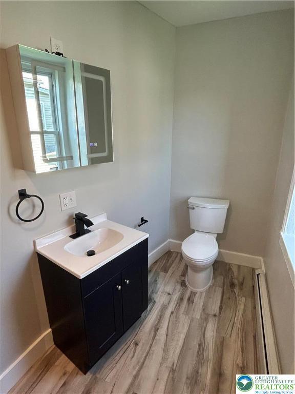 230 White St, Lehighton Boro, PA 18235 - half bathroom featuring a baseboard heating unit, wood finished floors, and vanity