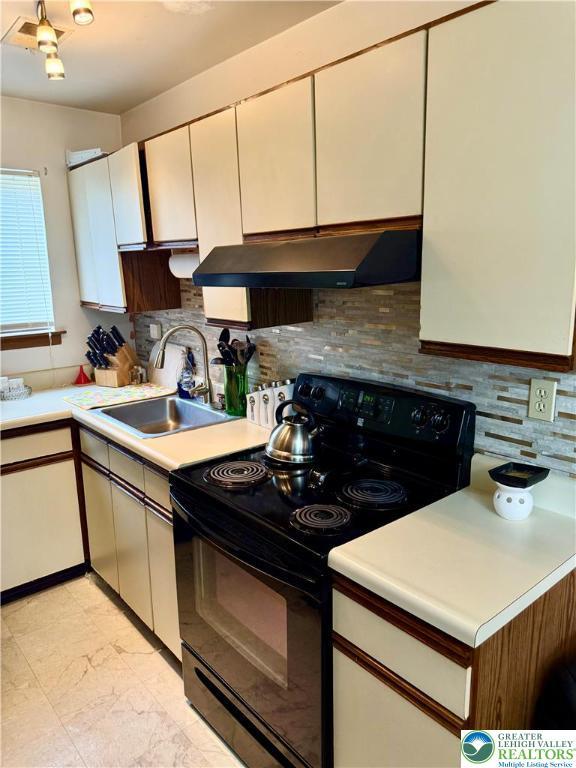 3353 Windermere Dr, Lehman Twp, PA 18324 - kitchen featuring black electric range oven, under cabinet range hood, light countertops, light marble finish flooring, and decorative backsplash