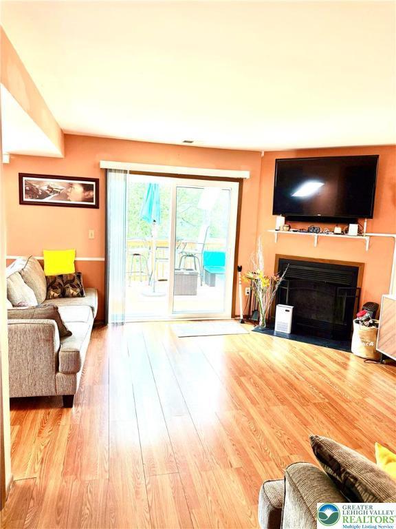 3353 Windermere Dr, Lehman Twp, PA 18324 - living area featuring a fireplace with flush hearth and wood finished floors