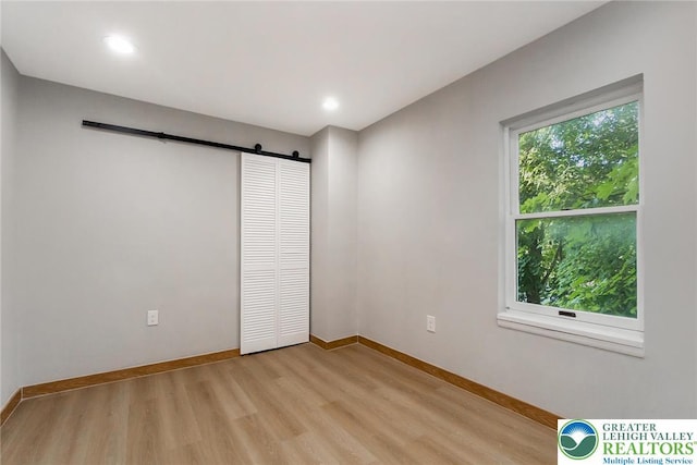 226 Fern St, Jim Thorpe Boro, PA 18229 - unfurnished bedroom with a barn door, light wood-style floors, recessed lighting, and a closet